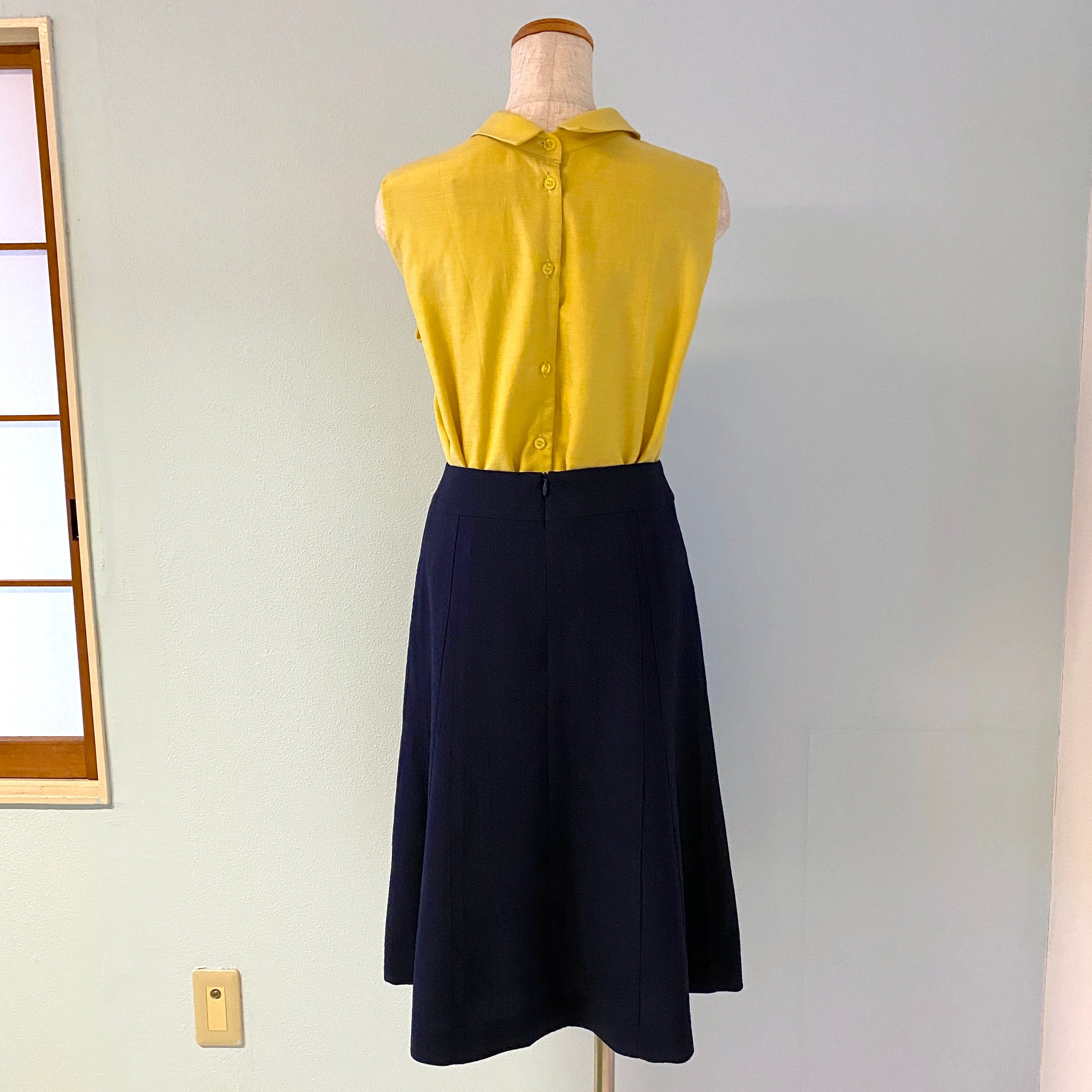 丸襟ノースリーブの黄色ブラウスとネイビーのシンプルなスカート